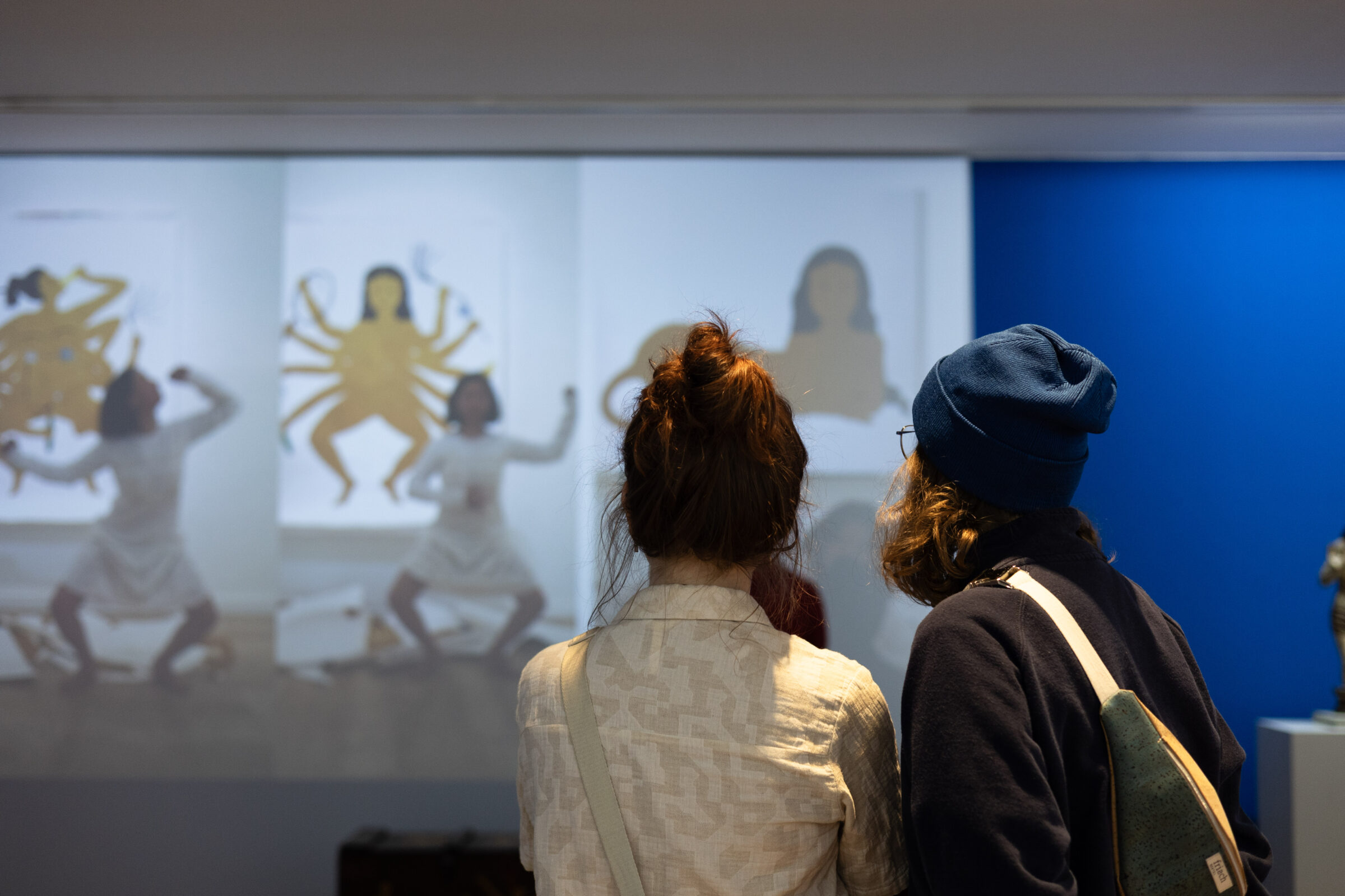 Besucherpaar sieht gespannt einer Videoinstallation der Künstlerin Kubra Khademi zu.