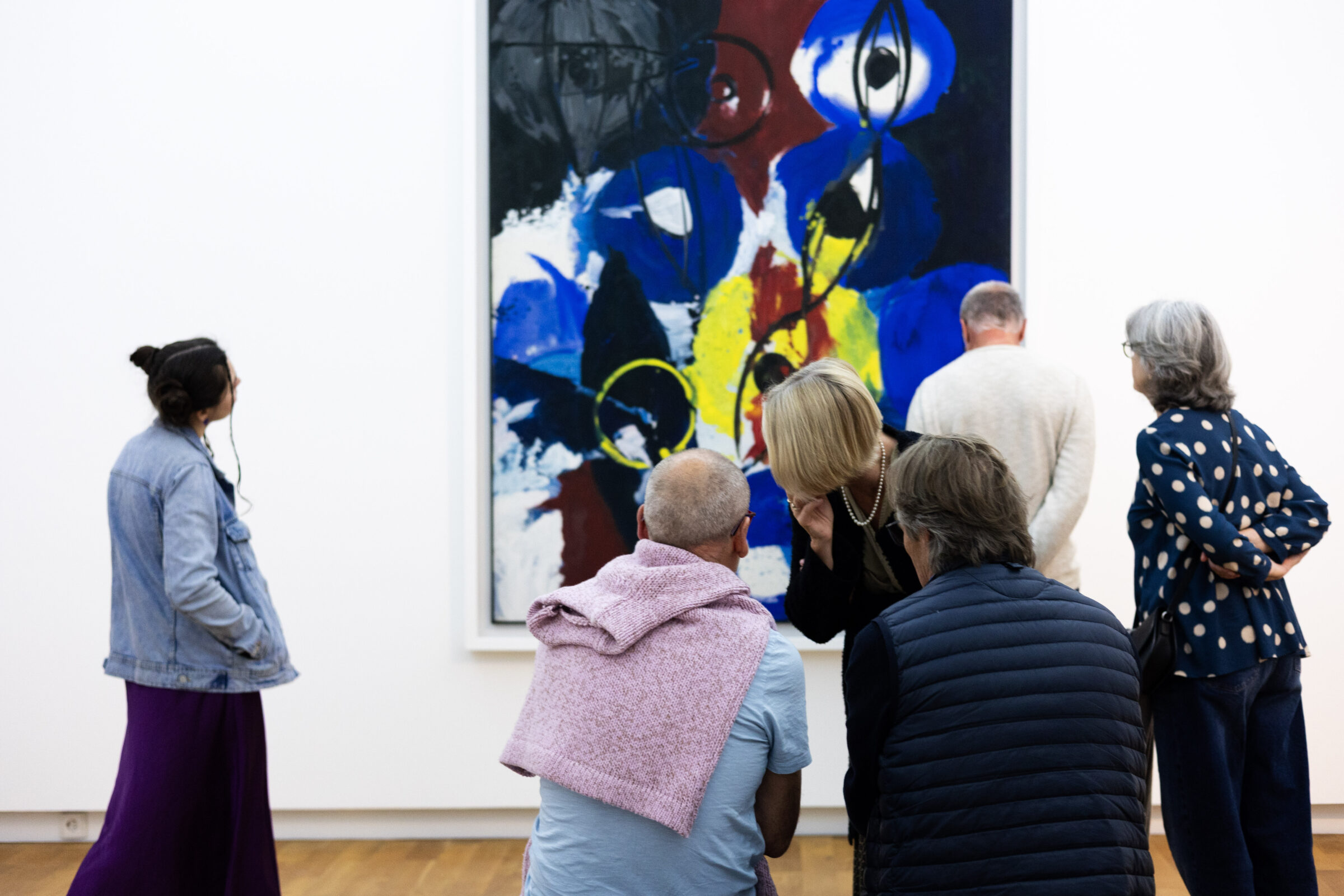 Gruppe Besucher:innen steht vor Wilhelm Nays "Licht" Gemälde