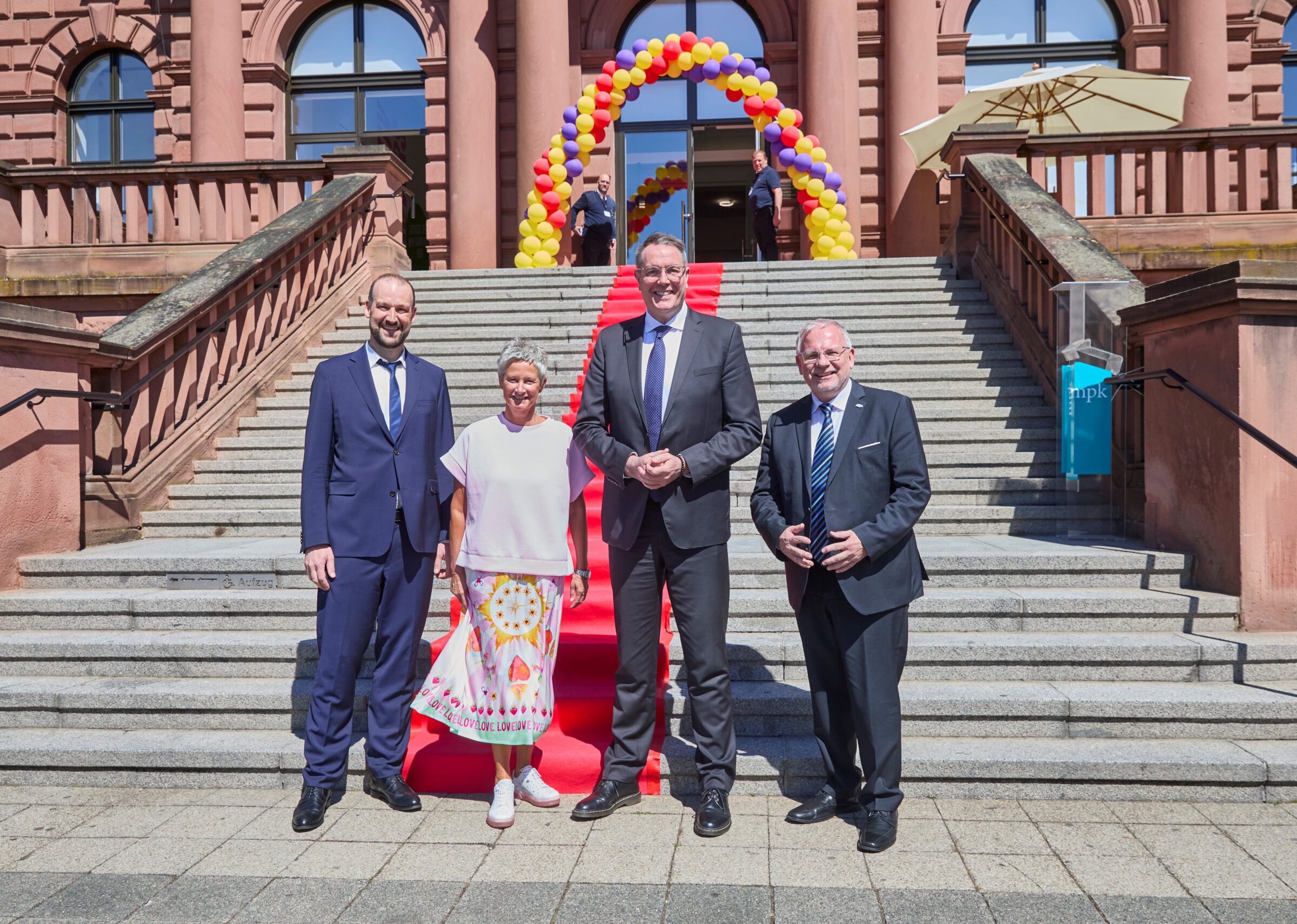 Direktor des mpk (Steffen Egle) posiert mit Oberbürgermeisterin der Stadt Kaiserslautern (Beate Kimmel), dem Ministerpräsidenten des Landes Rheinland-Pfalz (Alexander Schweitzer) und dem Vorsitzenden des Bezirkstags Pfalz (Hans-Ulrich Ihlenfeld) für ein Foto vor dem roten Teppich des mpk